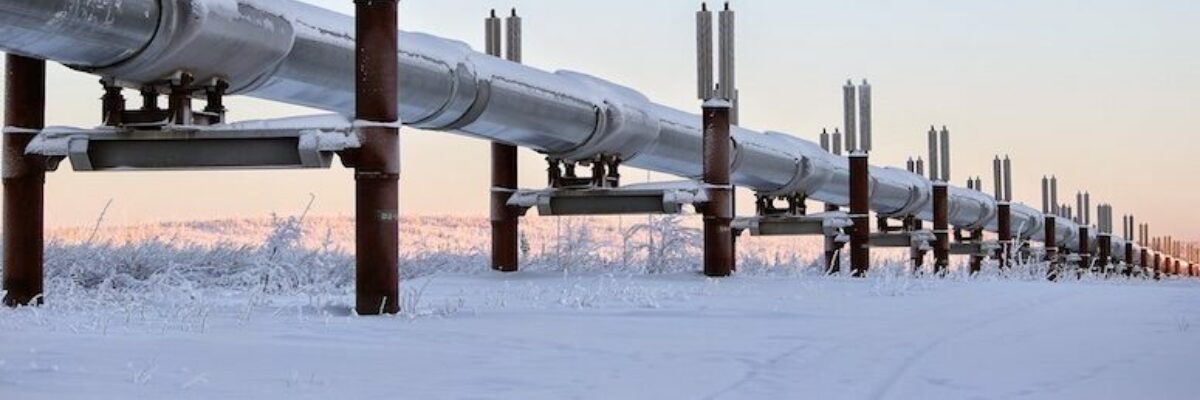 An above-ground pipeline cutting through a wintery landscape.