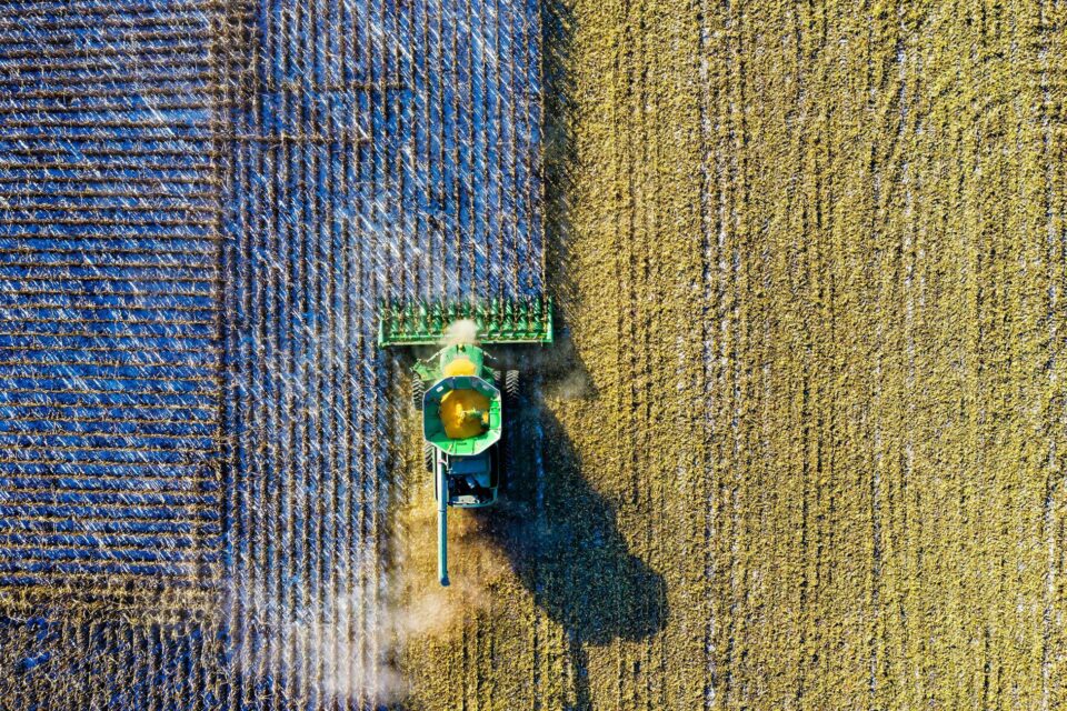 Top view of a tractor harvesting crops in a field.