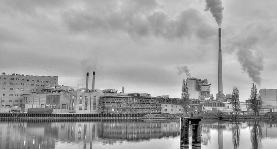 black and white smoke stacks and factory