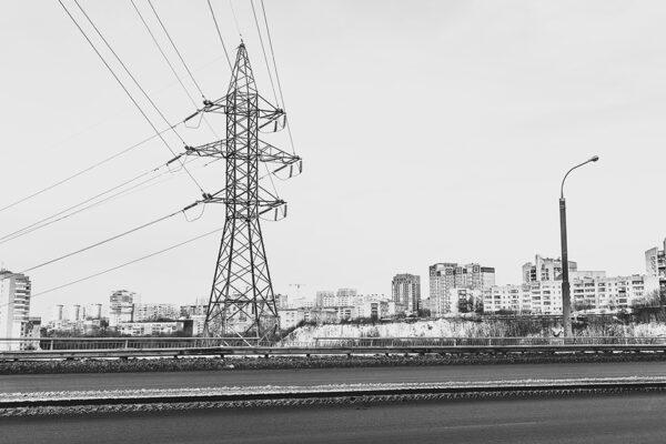 A black and white photo of residential buildings surrounding a transmission tower
