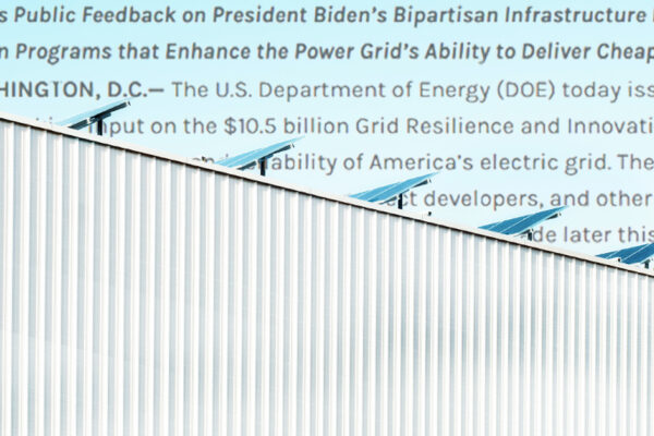 Solar panels on a building with corrugated metal siding; text from a Department of Energy press release sits in the sky behind the building