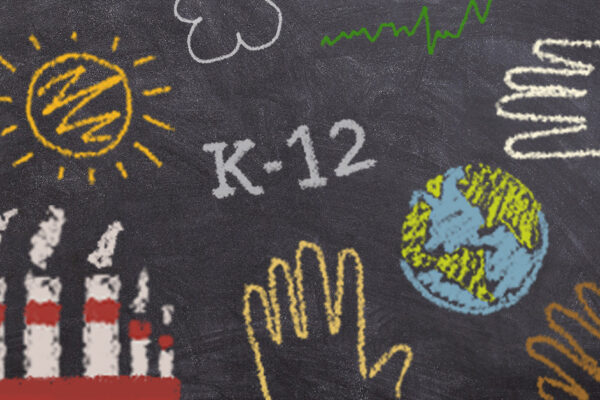 Several images drawn in colored chalk on a black chalkboard: a sun, clouds, the phrase "K-12," smokestacks, a line graph, and handprints surrounding the globe