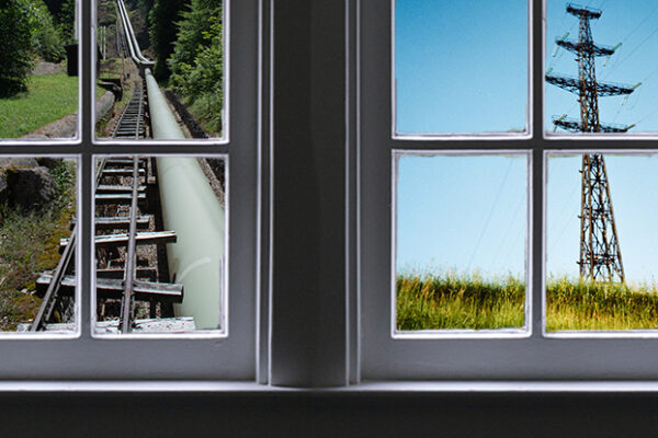 Two windows, looking out on views of a transmission tower and a pipeline.