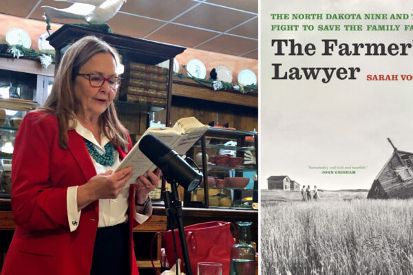 Author Sarah Vogel wearing a read blazer reading from her book The Farmer's Lawyer at a microphone.