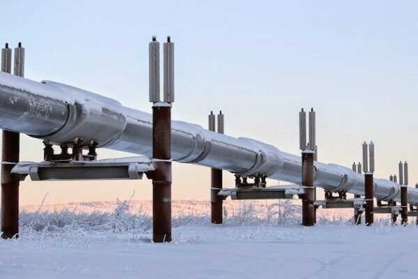 An above-ground pipeline cutting through a wintery landscape.