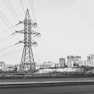 A black and white photo of residential buildings surrounding a transmission tower