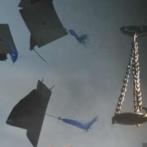 On the left, graduates through their caps into the air and hold diplomas. On the right, a bronze Lady Justice statue.