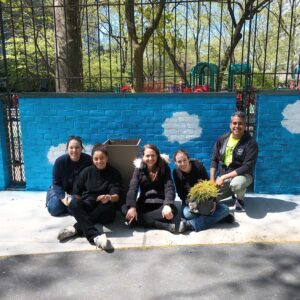 A photo of State Impact Center staff in front of a freshly painted wall at a park