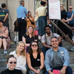 A photo of State Impact Center staff sitting on the stairs of the Met museum