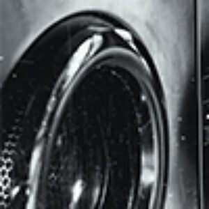 A closeup shot of a washing machine door that is partially open