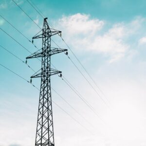 A transmission tower in front of a blue sky