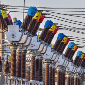 Distributers with brightly colored red, yellow, and blue parts are shown at an electric substation